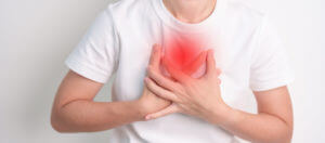 A woman is experiencing chest pain due to respiratory and cardiovascular system failure, including lung cancer and asthma, which are symptoms of emphysema.