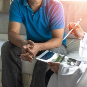 An image showing a male patient consulting with a doctor for a prostate check.